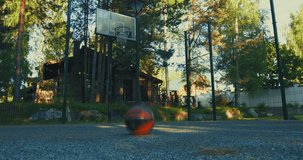 Basketball ball bouncing on basketball court ground outdoor in summertime. Outdoors workout concept