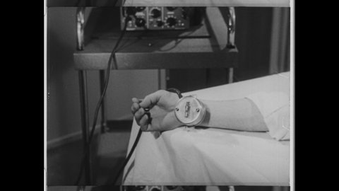 1950s New York, NY. A hand is connected to Early Oscilloscope, Cathode-Ray Oscilloscope. The  oscillator measure a patients heartbeat with a wavelength. 4K Overscan of Vintage Archival 16mm Film Print
