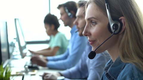 Business woman wearing headset working in office to support remote customer or colleague. Call center, telemarketing, customer support agent provide service on telephone video conference call.