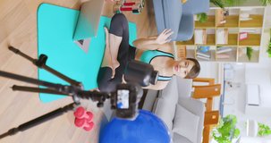 vertical of Asian pretty live streamer introduce a can of high protein milk powder online by digital camera and she just finish exercise