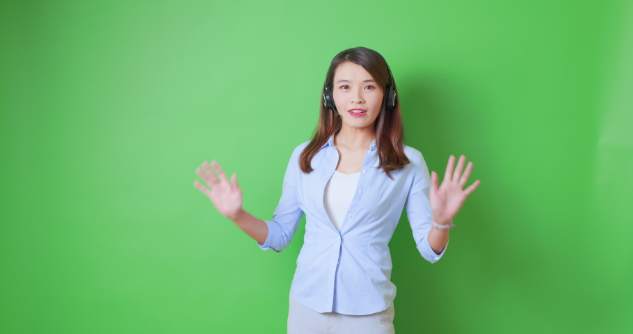 asian female confident anchor or live streamer wearing headset is show something on green background with ok gesture Royalty-Free Stock Footage #1076242343