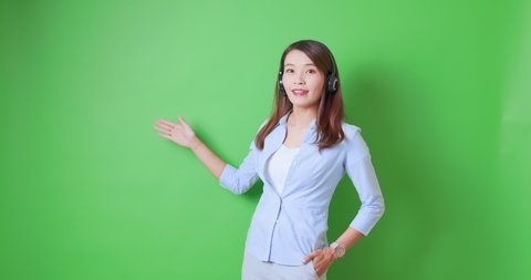 asian female confident anchor or live streamer wearing headset is show something on green background with ok gesture