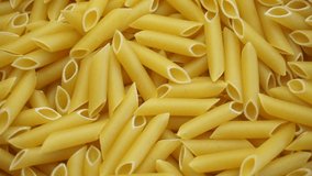 Overhead closeup of uncooked macaroni pasta rotating on a base