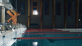 Beautiful Female Swimmer Diving in Swimming Pool. Professional Athlete Gracefully Jumps. Person Training Determined to Win Championship. Cinematic Slow Motion with Stylish Colors, Artistic Side View - Powered by Shutterstock - Get 15% off with code: PIKWIZARD15