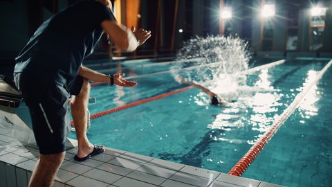 Swimming Pool: Professional Trainer Training Future Champion Swimmer. Experienced Coach Does High-Five with Successful Male Swimmer. Team Ready for World Record and Victory. Cinematic Slow Motion