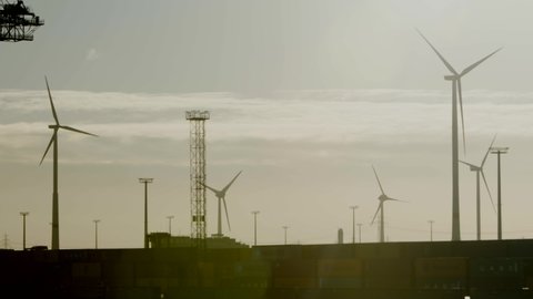 Container Terminal Burchardkai, Hamburg, Germany.  Circa 2020. Wind turbines harnessing energy at container port. 