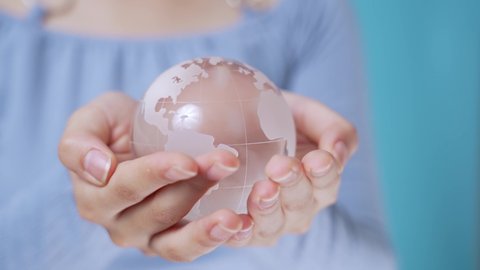 Young girl holding a glass globe. Environment concept.