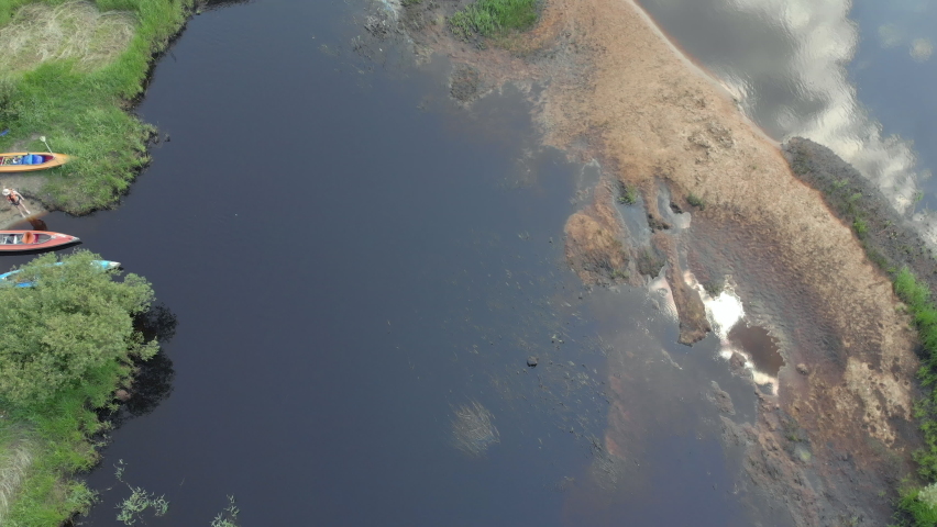 Tracking a Boat. Tourist base of kayaks and canoes, summer adventure kayak, rafting to canoe. Kayaking top view. Group of kayaks rowing together. Aerial view from drone.