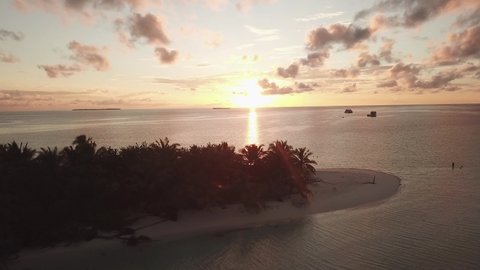 DLOG Flat Island in the sea. Maldives white sand beach tropical islands with drone aerial flying birds eye view with aqua blue sea water and sunny sky during sunset