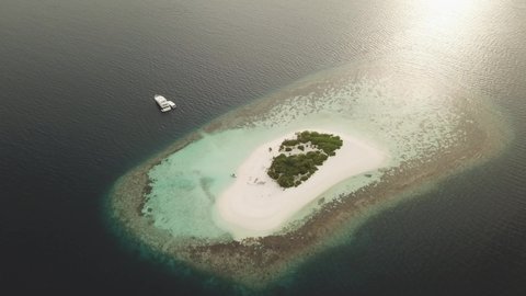 Flat Island in the sea. Maldives white sand beach tropical islands with drone aerial flying birds eye view with aqua blue sea water and sunny sky