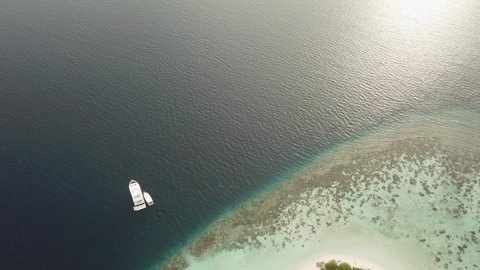 DLOG Flat Island in the sea. Maldives white sand beach tropical islands with drone aerial flying birds eye view with aqua blue sea water and sunny sky