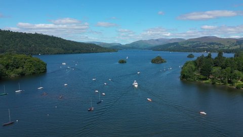 4K:  Drone Clip of Lake Windermere in the English Lake District, Cumbria, UK. Boat in foreground with Blue Sky. 