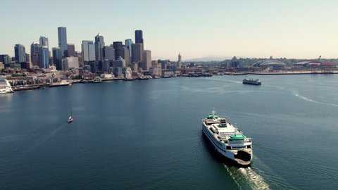 Massive Washington Ferry Boat Traveling Puget Sound Water to Seattle Waterfront. Aerial drone video of ocean passenger vessel arriving at port of major US city