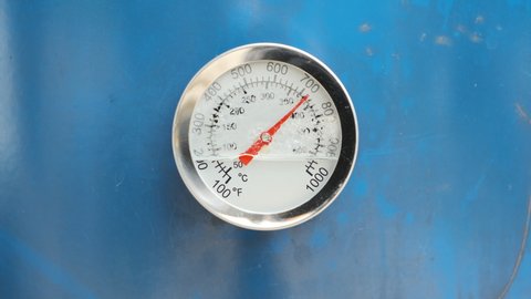 Broken used a Circular Temperature gauge thermometer for measuring hot and steam temperature mounted on blue metal. Industrial concept