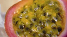 Macro shot of sliced fresh exotic passion fruit fruit rotating on a table. Slow motion video 4K