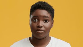 Huh, What Did You Say. Curious Black Woman Listening Holding Hand Near Ear Posing With Opened Mouth Over Yellow Background In Studio. I Listen And Hear You Concept. Slow Motion