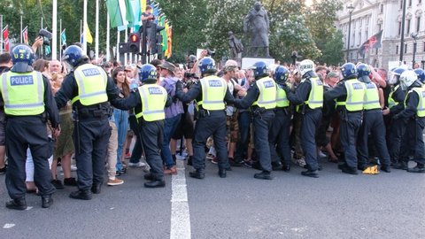 LONDON, UK – July 19, 2021: ‘Freedom Day’ anti-lockdown, anti-vaccination protesters attack Riot Police who are clearing protesters off road at Parliament Square, London, England, UK