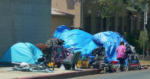LOS ANGELES, CALIFORNIA, USA - JUNE 28, 2021: Homeless and mental ill people living in tent camp during homelessness crisis and coronavirus COVID-19 pandemic outbreak in Los Angeles, California, 4K
