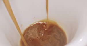 Making homemade coffee. A coffee machine from which aromatic Americano or cappuccino coffee flows into a cup for breakfast in the morning. 4K reserved video.