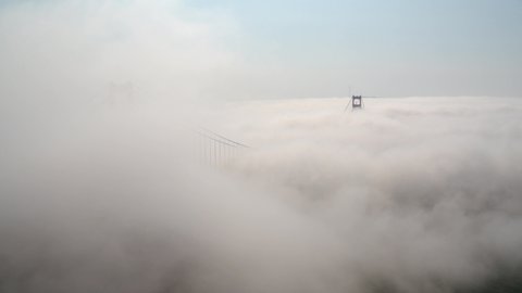Cinematic Aerial drone footage of heavy fog surrounding the Golden Gate Bridge in San Francisco, California, USA 
