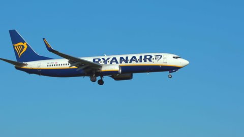 Oslo Airport Norway - July 16 2021: airplane boeing 737 ryanair sun in flight panning right sunny day slow motion