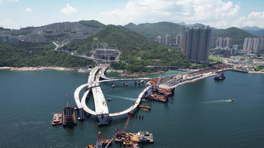Large-scale sea traffic viaduct bridge with two-lane carriageway, cycle track, and footpath under construction works in Lohas Park, Tseung Kwan O of Hong Kong city, Kowloon Aerial Top view | Shutterstock HD Video #1076291774