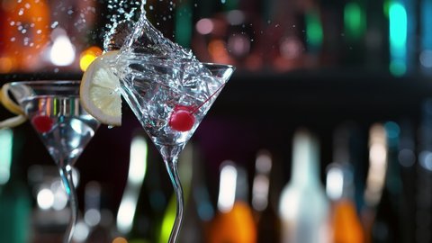 Super slow motion of falling ice cube into cocktail drink, camera movement. Speed ramp effect. Filmed on high speed cinema camera, 1000 fps.