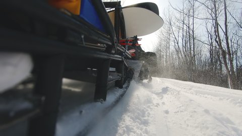 Camera on side of sleigh attached to snowmobile capturing magnificent view of wood on winter. Sport equipment transported to the next location on sunny morning. Concept of holiday, extreme sports.