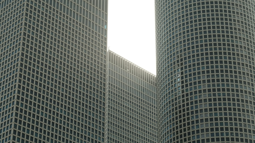 A telephoto view of an urban scene, where 3 high rises buildings are merged into one in a compressed composition. a 4K video clip, Tel Aviv, Israel.