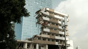 A partly demolished old building next to a shiny new one in an urban environment. a 4K video clip, Tel Aviv, Israel.