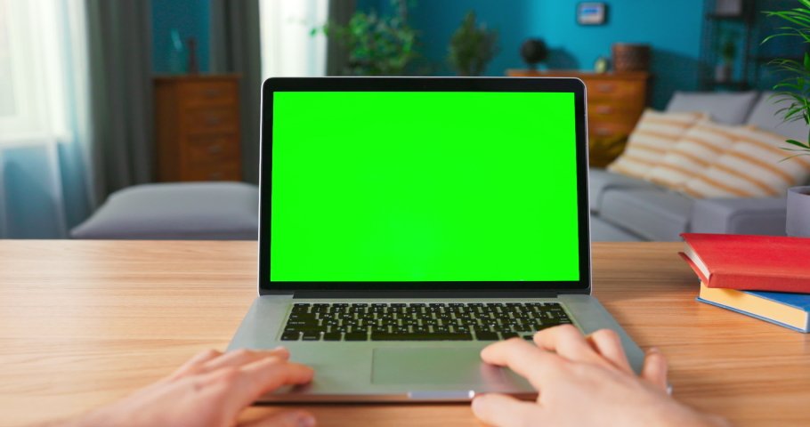 Close up of male Hand is using laptop touch pad. Modern Personal Computer with Mock-up Green Screen Display Standing on the Desk of the Cozy Home. | Shutterstock HD Video #1076305823