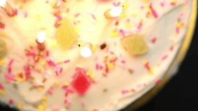 Animation of gold confetti falling over lit candles on birthday cake, blown out. birthday, celebration, party, tradition and event concept digitally generated video.