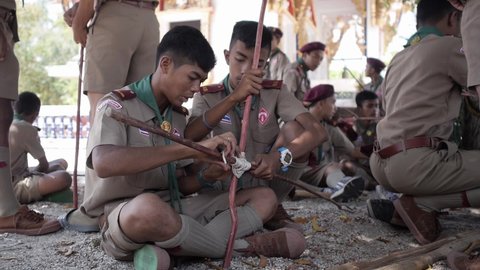 Sai Khao Pattani, Thailand, March 18, 2016: Thai Boy Scout activities group of students boys in uniform making wooden catapult join sticks tie with a rope, school teams together learn to build a frame