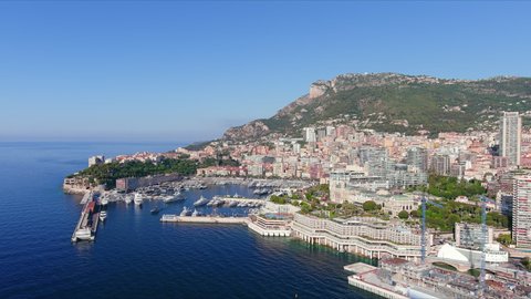 Monte Carlo, Monaco. Aerial view of famous city towering over Mediterranean Sea, Monte Carlo Casino in center of city, marina Port Hercules, clear blue sky - landscape panorama of Europe from above