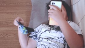 asian kid using smartphone and show funny expression. High quality 4k footage