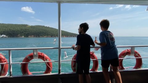 Children throw bread to seagulls from the ferry in the Sea of Marmara near Adalar archipelago in Istanbul, Turkey. May 30, 2021.