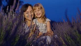 Happy young mother and little girl daughter kid kissing and laughing in aromatic flowers lavender field garden on summer night sunset. Family, childhood, motherhood, fairytale, provence style concept - Powered by Shutterstock - Get 15% off with code: PIKWIZARD15