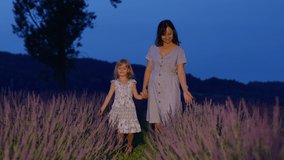 Adorable little cute daughter walking with mother in lavender field, playing with flowers. Child girl kid wearing dress enjoying time, holding hands of loving parent outdoors, aromatic flowers. Family - Powered by Shutterstock - Get 15% off with code: PIKWIZARD15