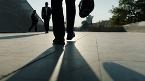 Low angle view of legs in formal trousers and shoes walking outdoors near business center while men and women are going to work. People and city concept. - Powered by Shutterstock - Get 15% off with code: PIKWIZARD15