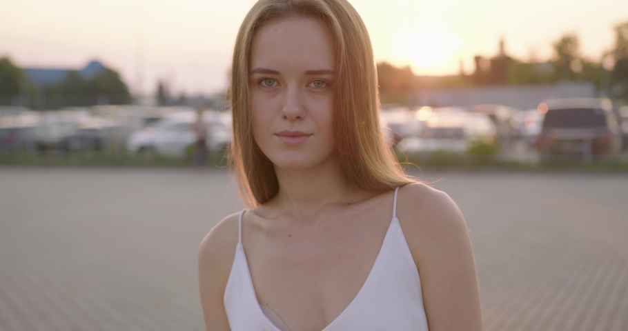 Charming young woman in summer clothes posing alone on city street. Playful mood of caucasian blonde. Lifestyles concept.