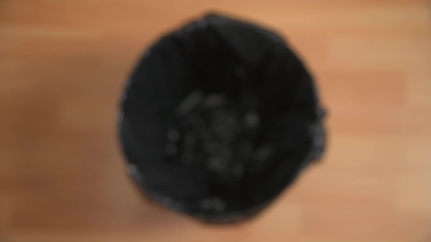 Aerial shot of dropping a black fabric mask into a bin to show lockdown restrictions easing and a return to normal Royalty-Free Stock Footage #1076322527