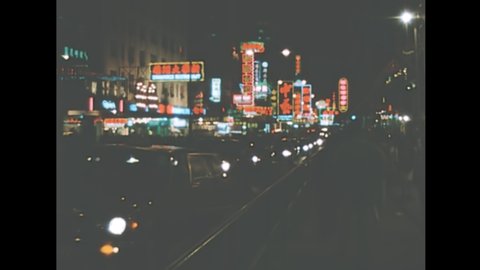 HONG KONG, CHINA - CIRCA 1987: Vintage nightlife of Hong Kong downtown with street lights of Chinese stores with car traffic. Historic archival in 1980s.