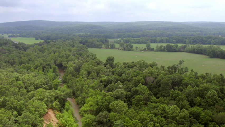 Overhead field and trees with stream on a cloudy day in Farmington in southern Missouri.