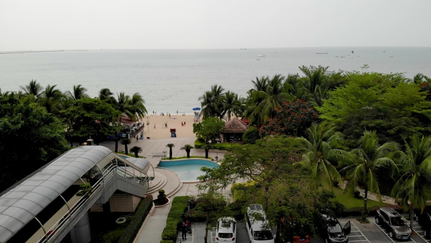Flying out over beach in Sanya. Tourist area in Chinese resort area with many pleasure and tourist boats anchored in the bay.