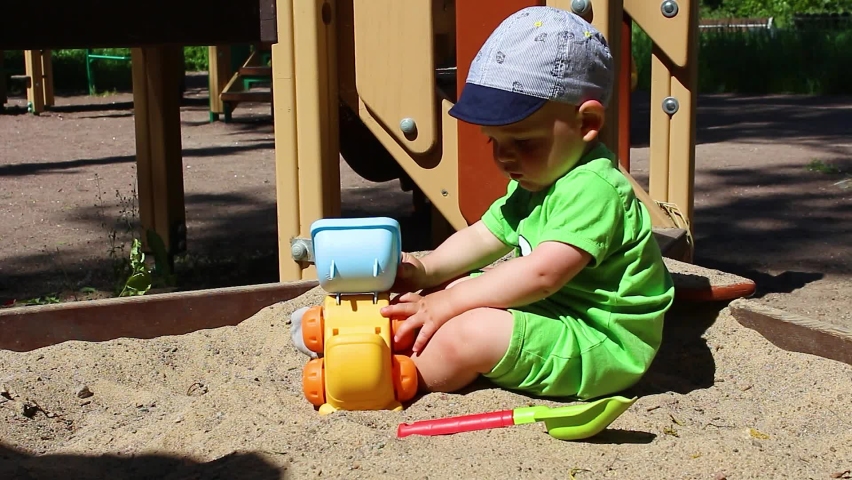 Adorable caucasian baby boy playing with car.