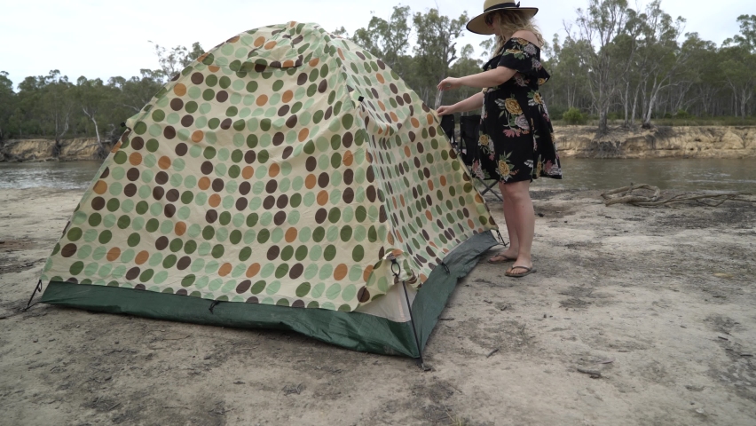 Blonde woman unzipping tent camping in Australia
