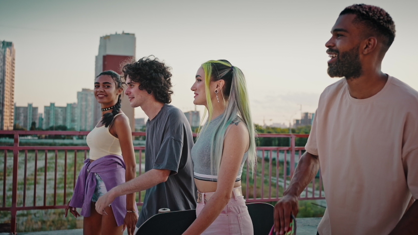 Friendship and inner connection. Group of happy multiethnic friends walking together in urban area, laughing and giving high five to each other, slow motion Royalty-Free Stock Footage #1076355002