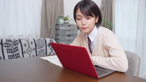 Asian female student taking online class. e-learning. Remote work.