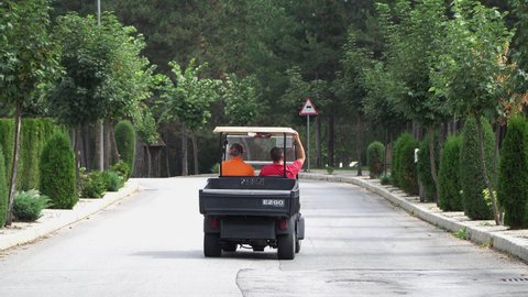 Bansko, Bulgaria - 12 Mar, 2021: Golf players use golf-cart for transportation in urban street in Bansko, Bulgaria
