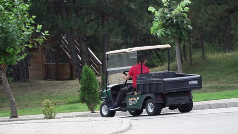 Bansko, Bulgaria - 12 Sep, 2020: Golf players use golf-cart for transportation in urban street in Bansko, Bulgaria